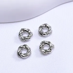 Vista macro de cuentas espaciadoras plateadas trenzadas con circonitas para joyería