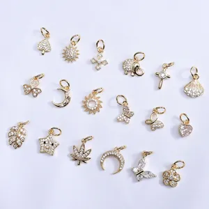 Vue détaillée de breloques plaquées or 14 carats avec zircons en formes de papillon et étoile