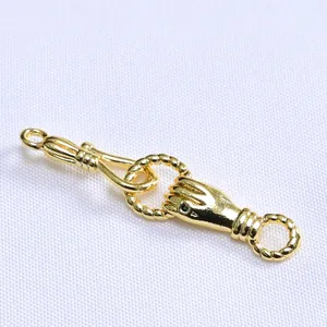 Macro detail of 14k gold lily of the valley hand clasp with green stone for jewelry making