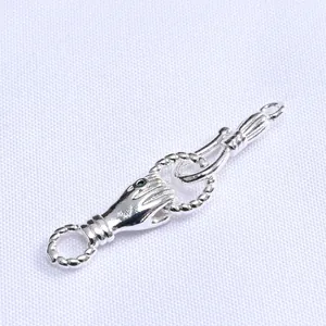 Detailed view of silver hand-shaped jewelry clasp with green gemstone for necklaces