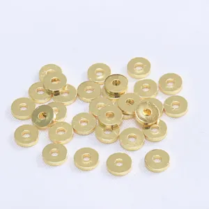 Vista macro de cuentas espaciadoras planas de 1 mm bañadas en oro 18K para joyería diy
