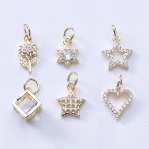 Macro view of 14k gold-filled charms with zircon stars, flowers, and hearts for DIY jewelry