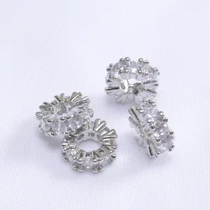 Vista macro di quattro distanziatori in argento placcato oro 14k con micro-pavé di zirconi