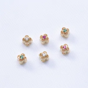 Primer plano de cuentas separadoras de trébol en oro de 14K con circonitas para joyería artesanal