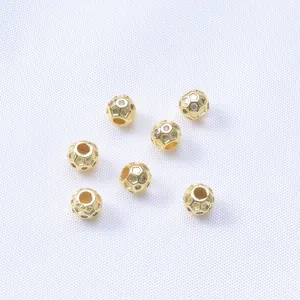 Detailed macro view of 14K gold-filled spacer beads with hollow honeycomb texture and zircon