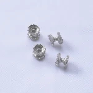 Macro detail of silver wave spacer beads with radial texture for jewelry making