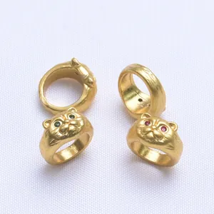 Détail de perles tête de chat en or mat avec des yeux en zircon rouge et vert