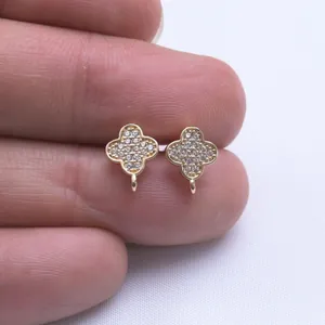 14k vergoldete S925 Silber Kleeblatt-Ohrstecker mit Zirkonia-Besatz in der Hand gehalten
