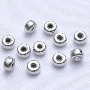 Dettaglio macro di spesse perline distanziatrici argentate con finitura a specchio per fai-da-te