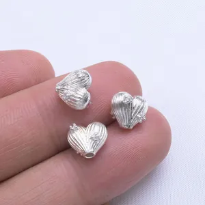 Three silver heart-shaped spacer beads with vertical stripes for DIY jewelry making