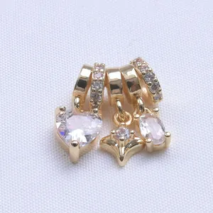 Macro shot of 14k gold plated heart and star charms with micro-pave cubic zirconia crystals