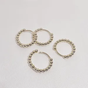 Macro shot of gold beaded hoop earrings with a textured surface for jewelry making