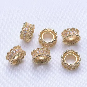 Vue macro de perles intercalaires ajourées en plaqué or 18k avec zircons roses et blancs