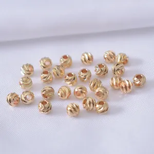 Makroaufnahme von 14k goldgefüllten facettierten Perlen mit Spiralmuster für DIY-Schmuck