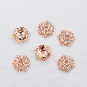 Detailed macro view of 14k gold-filled rose gold flower spacers with inlaid zircon
