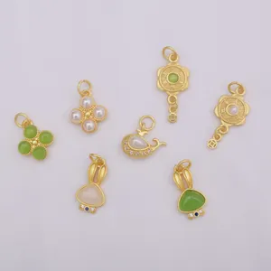 Detailed collection of matte gold charms including clover, rabbit, and whale designs