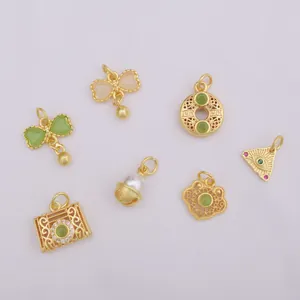 Detailed view of various gold-plated charms including lucky symbols and floral patterns