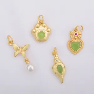 Matte gold pendants in butterfly, heart, and shell shapes with green stones and pearls