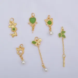 Detailed view of matte gold pendants with green enamel and pearls for DIY jewelry making