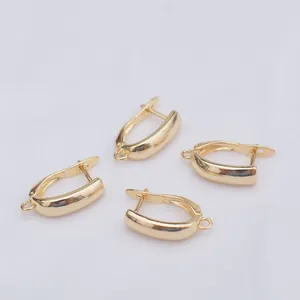 Detailed close-up of four 14k gold-filled U-shape earring hooks on white fabric