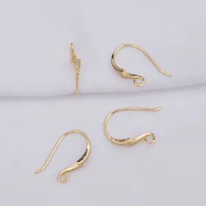 Detail van 14K vergulde oorhaken met micro-pave zirkonia op witte stoffen ondergrond