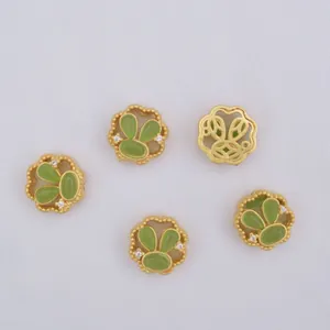 Detailed view of 5-piece gold rabbit-ear pendants with green stones and openwork design