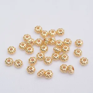 Cuentas espaciadoras doradas en forma de flor para joyería DIY sobre fondo blanco