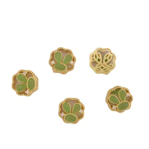 Ancient gold rabbit clover pendants with green stones and zircon accents on white background