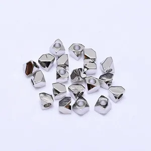 Detailed macro view of 17 irregular silver polyhedron metal beads for DIY jewelry making
