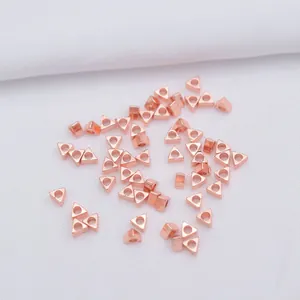 Macro view of 14k gold-filled rose gold triangle hollow beads for DIY jewelry making