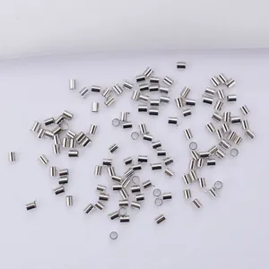 Polished silver crimp beads and jewelry tubes on white fabric for DIY necklace making