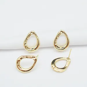 Irregular 14k gold plated teardrop stud earrings with hammered texture on white fabric