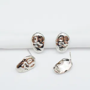 Detailed view of silver irregular lava-style stud earrings with liquid metal texture