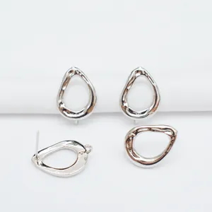 Macro detail of irregular hollow teardrop earring studs in polished 925 sterling silver