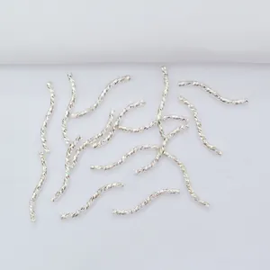 Textured 14k gold plated wave tube spacers for DIY jewelry making on white fabric