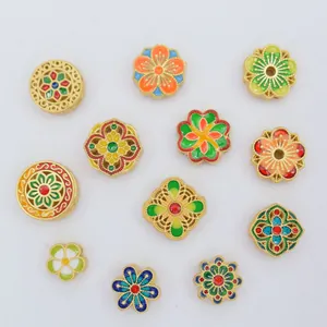 Close-up of colorful enamel floral beads and gold alloy spacers for DIY jewelry