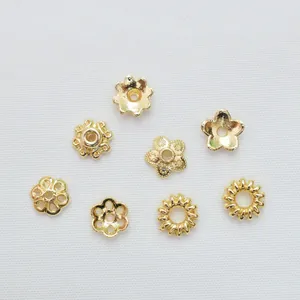 Dettaglio macro di perline distanziatrici a fiori placcate in oro 14k per gioielli