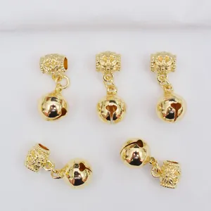 Détail de cinq breloques cloches dorées 14 carats avec bélière fleurie sculptée