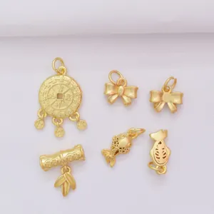 Macro shot of matte gold-plated lotus, bow and bamboo pendants with sandblasted finish