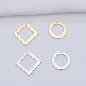 Macro view of geometric gold and silver plated metal charms with wavy serrated edges