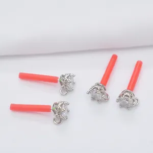 Nahaufnahme von kronenförmigen Ohrstecker-Komponenten aus Silber mit glänzenden Steinen