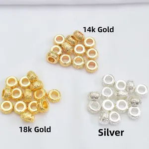 Detailed macro view of 18k and 14k gold-plated geometric pattern beads for DIY jewelry