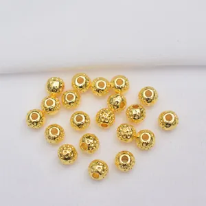 Close-up of gold-plated 14k hammered texture beads for DIY jewelry making and crafts