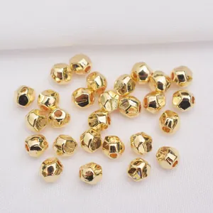 Macro shot of 14k gold-plated faceted drum beads for DIY jewelry making and bracelet crafts