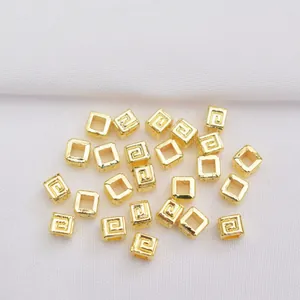 Macro detail of 14k gold-filled square hollow spacer bead with Greek fret pattern for DIY