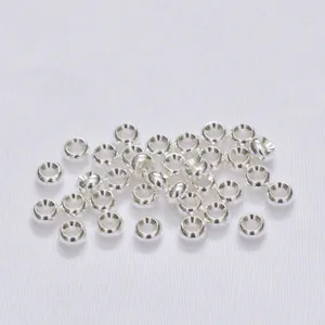 Gros plan de perles d'espacement en métal argenté poli pour la création de bijoux DIY