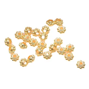 Goldene 14k sonnenförmige Zwischenperlen für DIY-Schmuck auf weißem Hintergrund