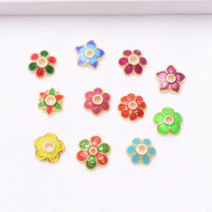 Makroaufnahme verschiedener Emaille-Blumenperlen mit Goldbeschichtung für DIY-Schmuck