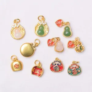 Traditional gold-plated charms with enamel gourds and lucky characters on white fabric
