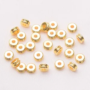 Vista macro de cuentas espaciadoras planas de latón chapado en oro 18k para joyería artesanal